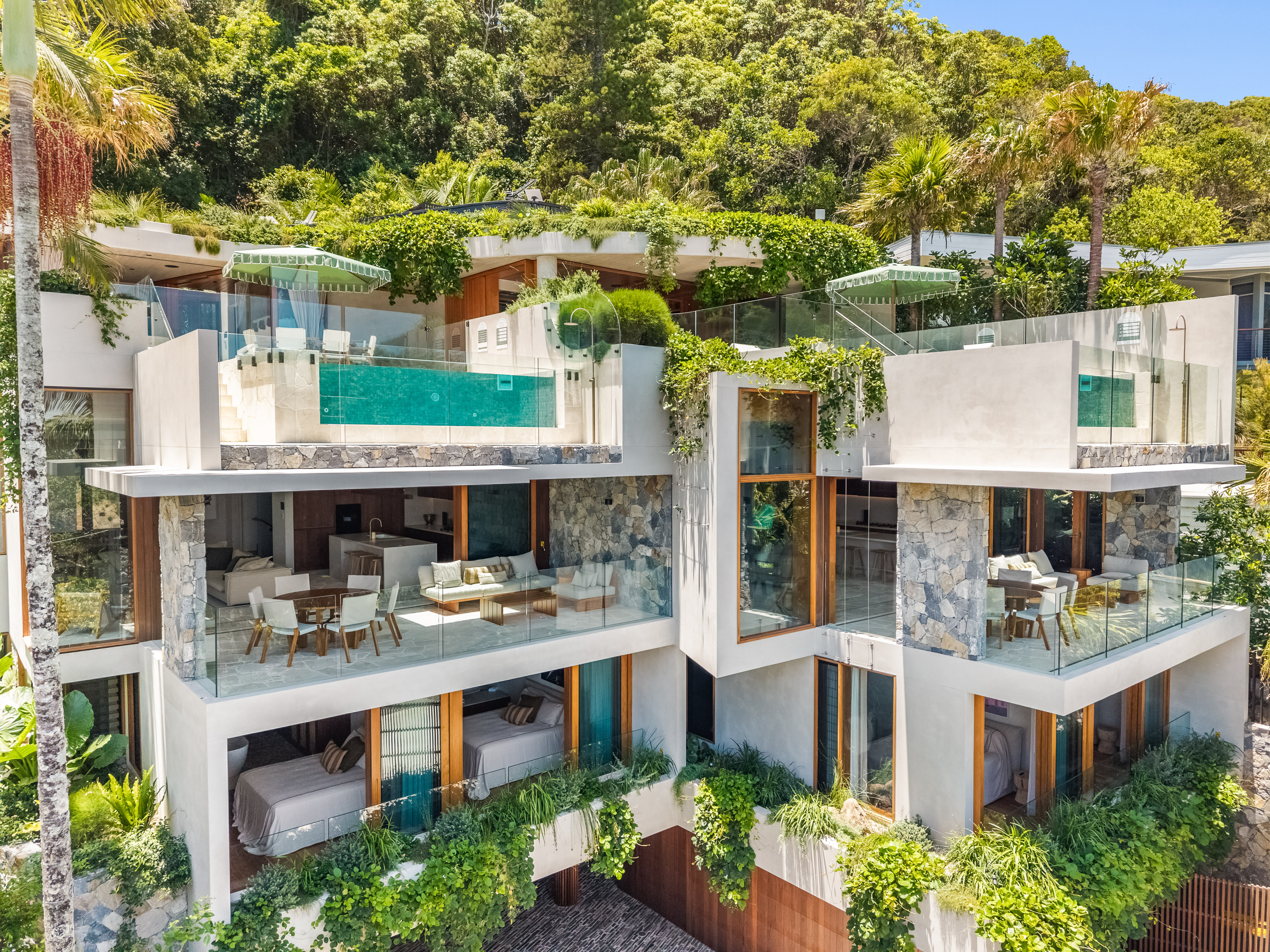Drone close-up showing the multi-level facade, pool and terraces — professional property photography Byron Bay