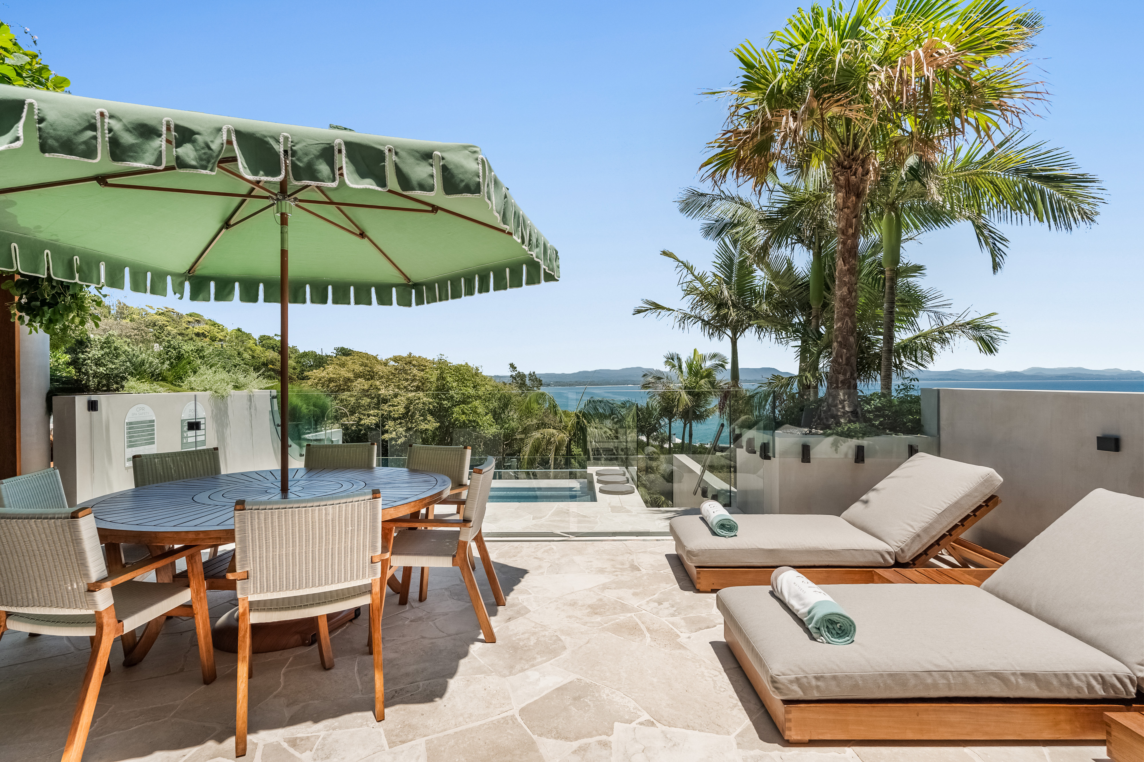 Pool terrace with ocean views, lounges and outdoor dining — luxury property photography Byron Bay