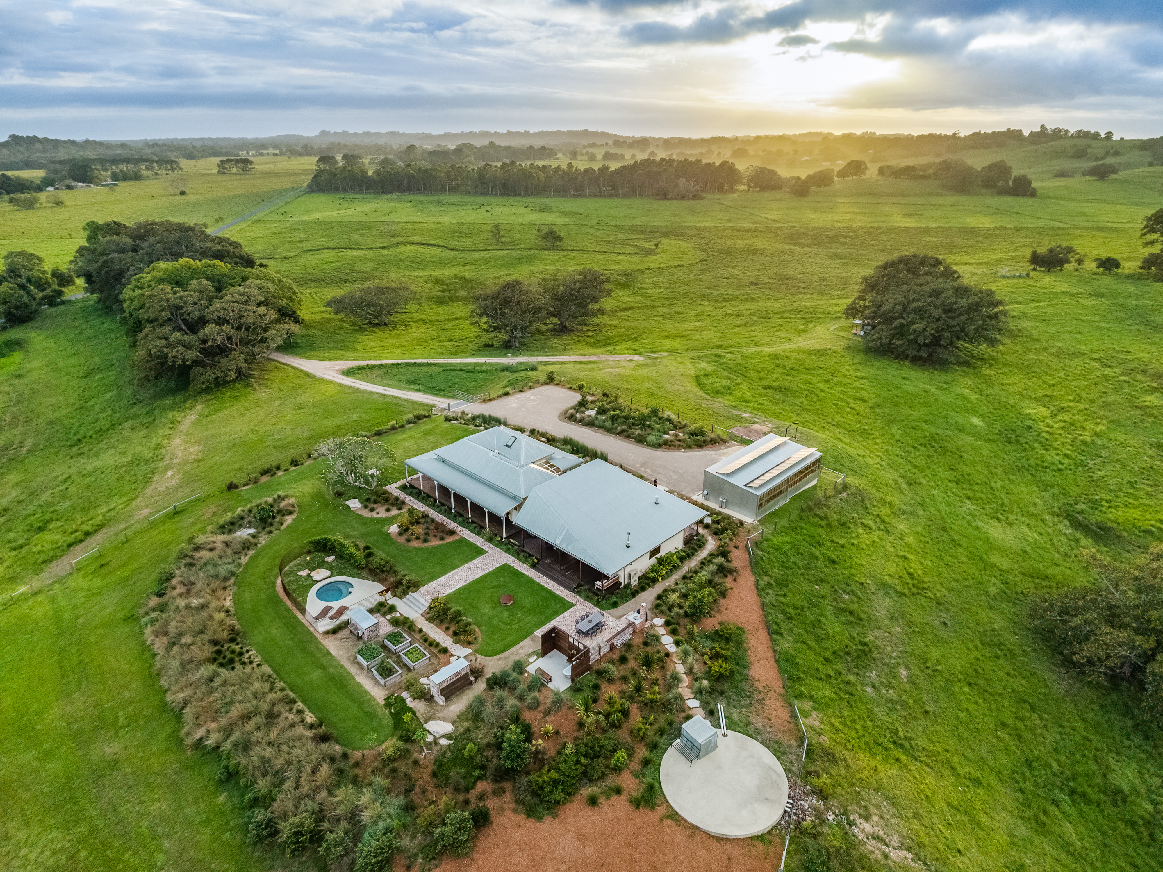 Wide aerial of property at sunrise showing full 101 acres and mountain ranges