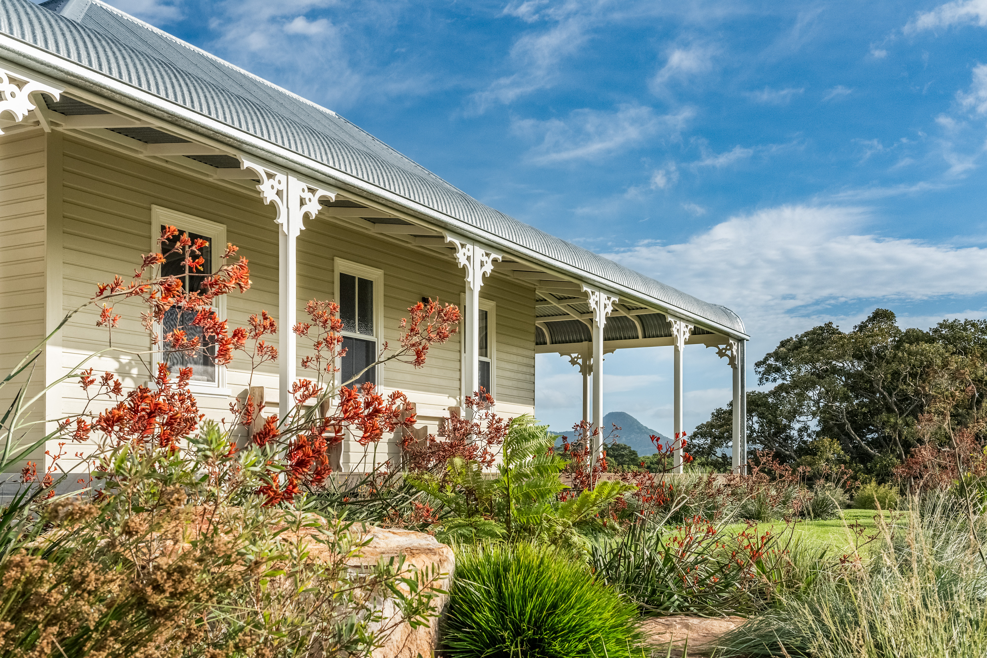 Heritage homestead verandah with ornate fretwork and Mt Chincogan views
