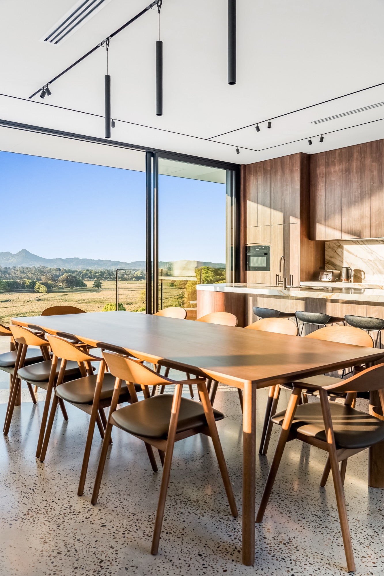 Dining room and walnut kitchen with mountain views and pendant lighting