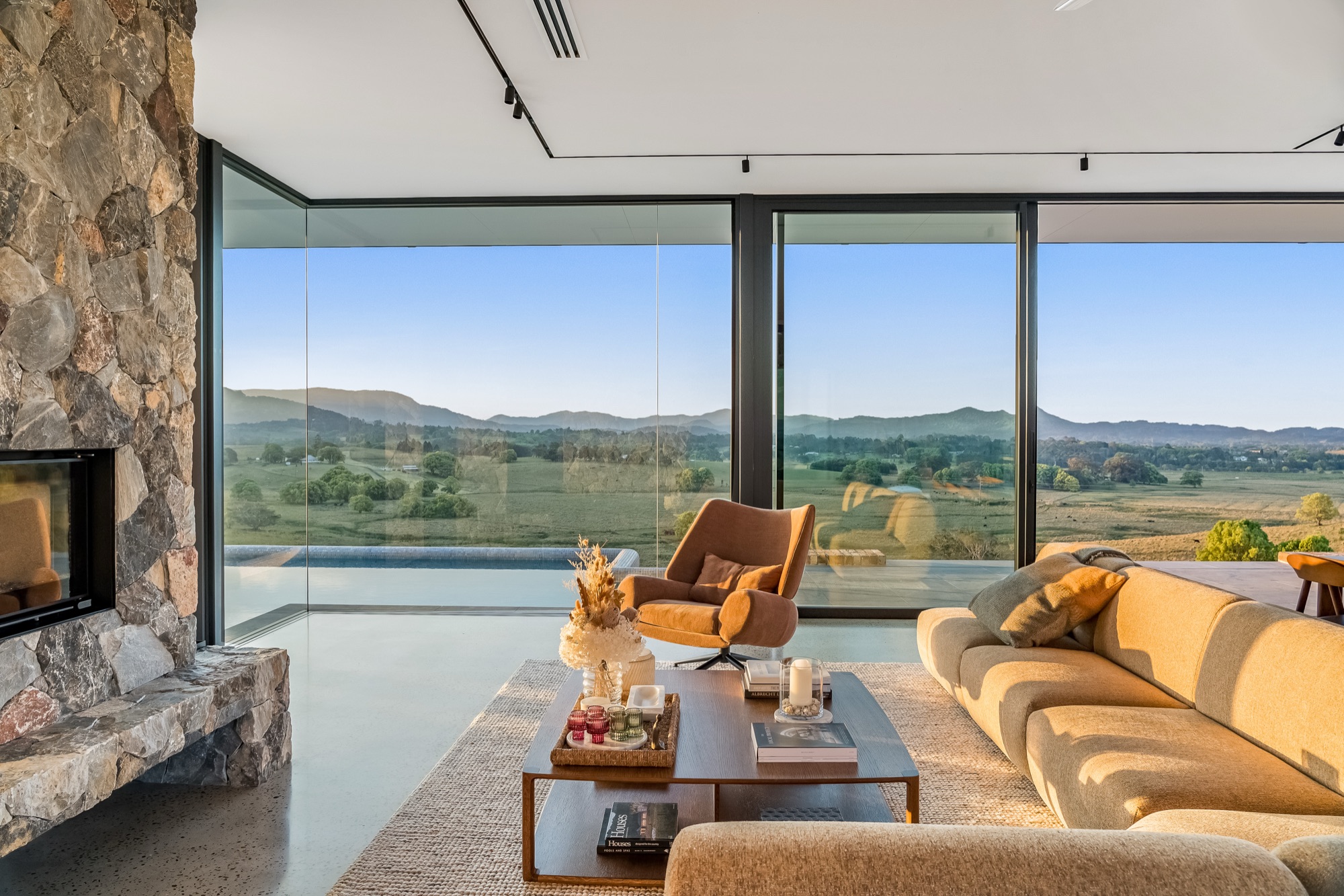 Living room at golden hour with sunset streaming past stone fireplace