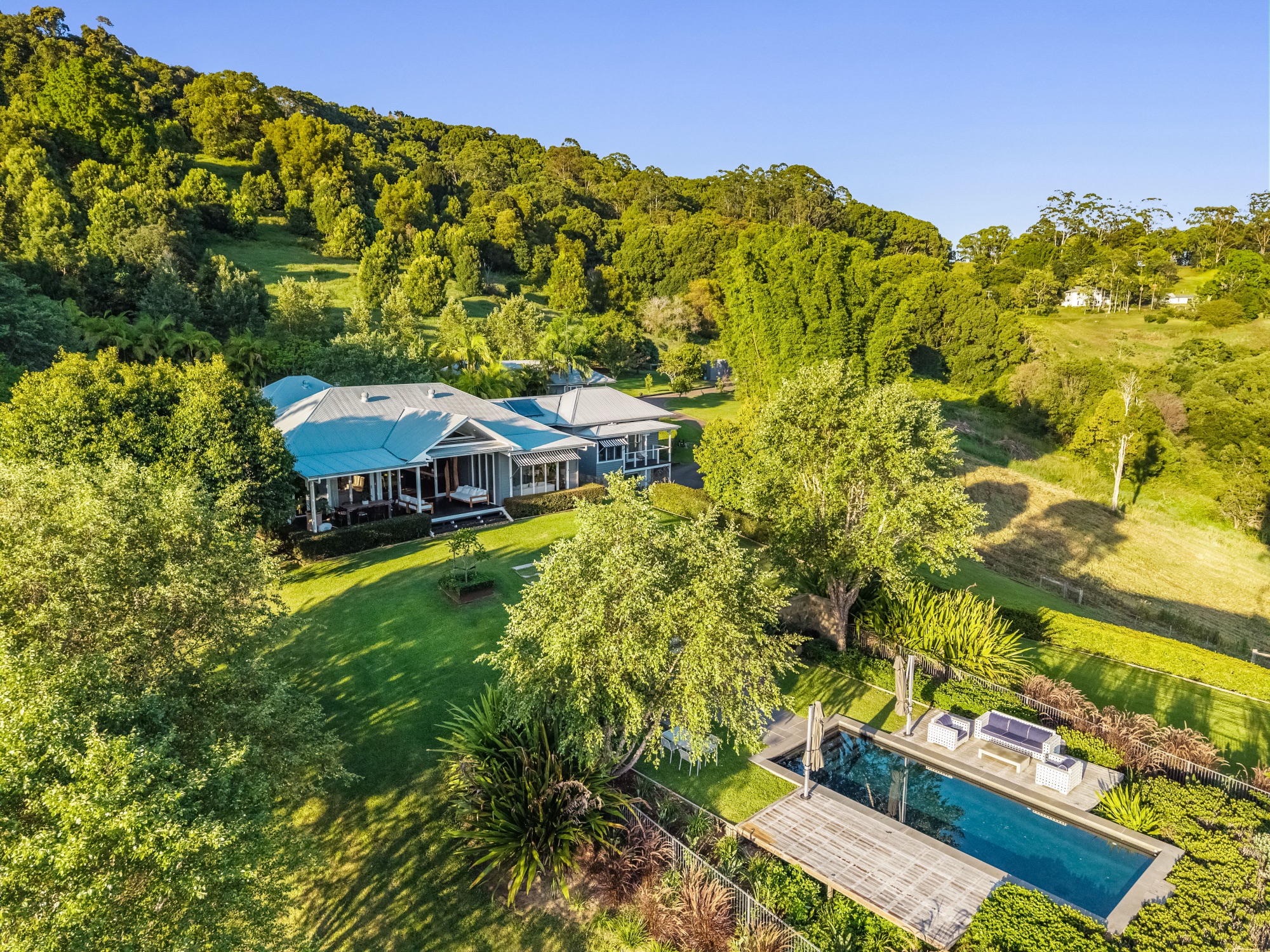 Mid-elevation aerial showing homestead, pool, guest residence and manicured gardens