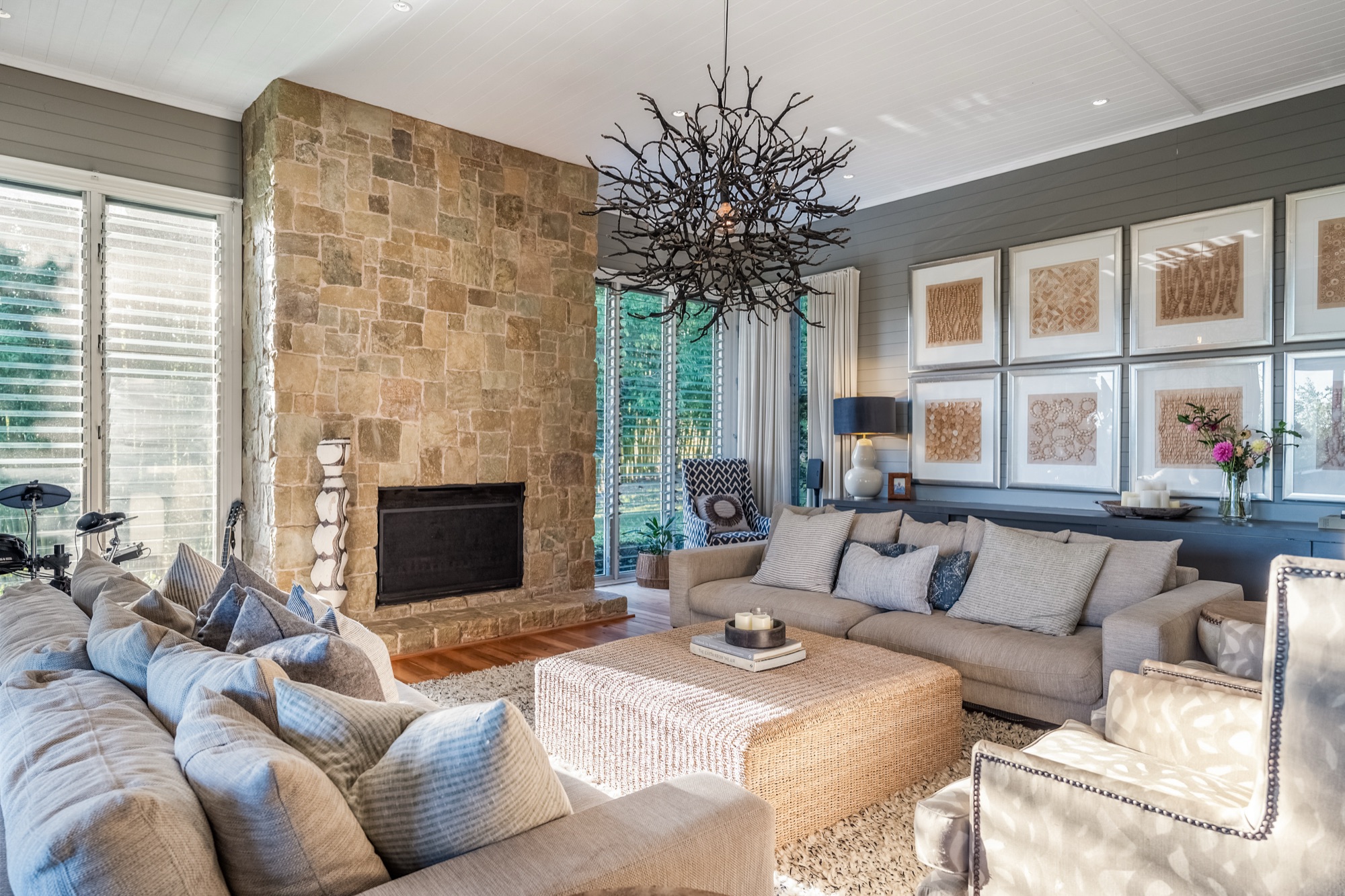 Living room from opposite angle showing gallery wall, sandstone fireplace and curated styling