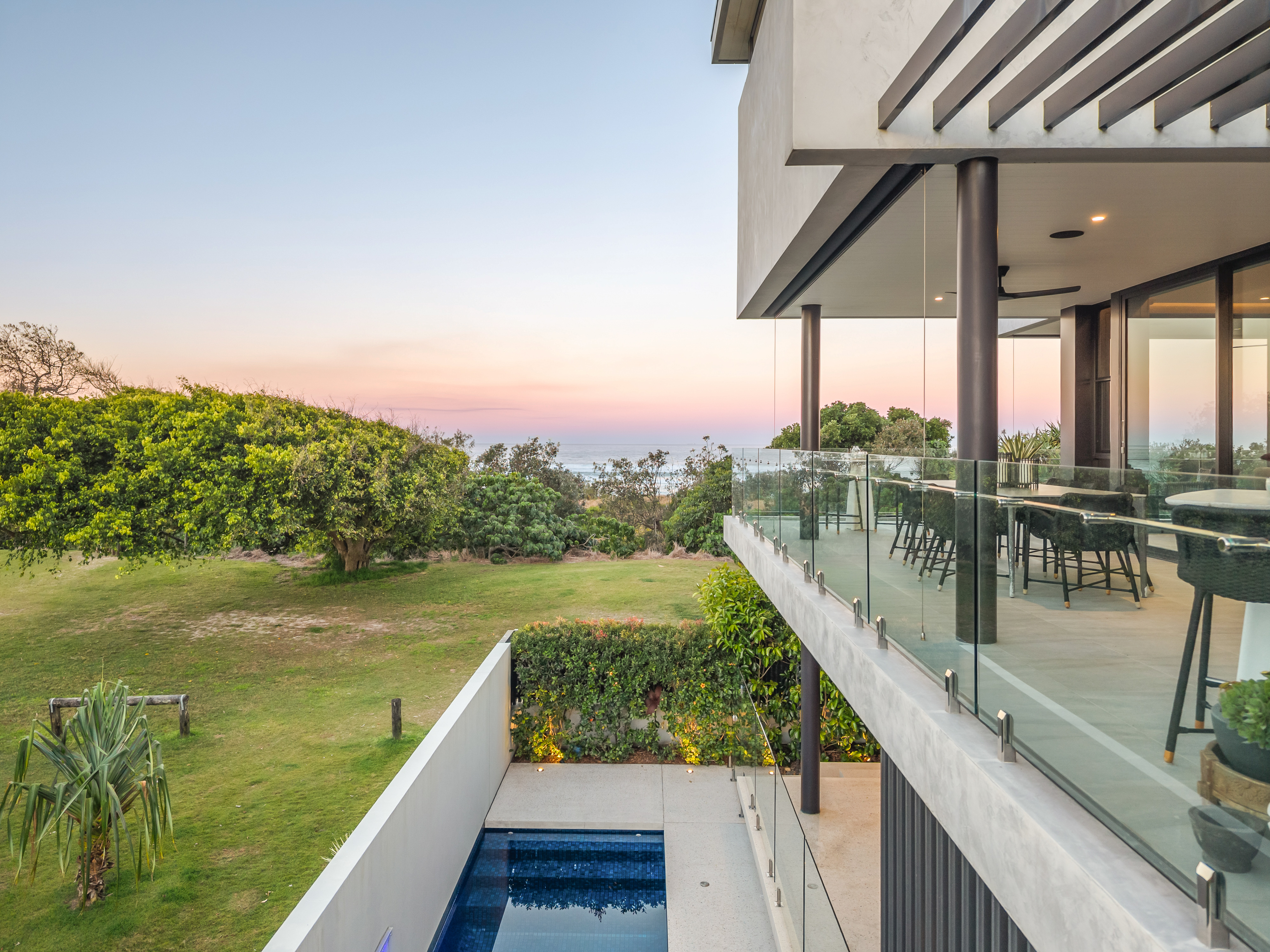 Balcony view at dusk with plunge pool and ocean — twilight property photography Hastings Point